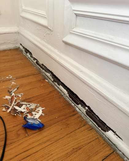 Baseboard with peeling layered paint before prep in a Chicago home on W Granville Ave