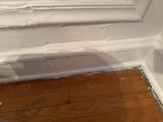 Baseboard and wainscot molding after scraping, patching and repainting in a Chicago home on W Granville Ave