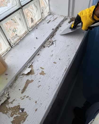 Bathroom window sill with peeling and flaking paint before repair in Chicago